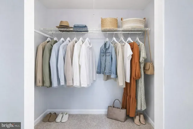 a view of walk in closet with clothes and shoes