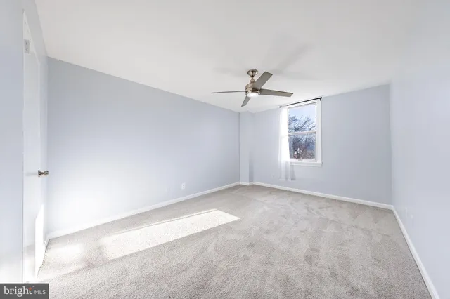 a view of an empty room with a ceiling fan