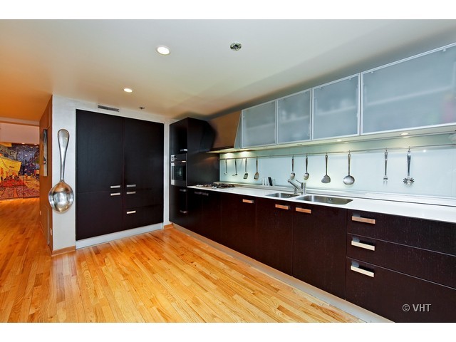 1000 West Washington Boulevard, Unit 428 Chicago, IL 60607 - Photo 5 of 16 a kitchen with kitchen island sink and refrigerator