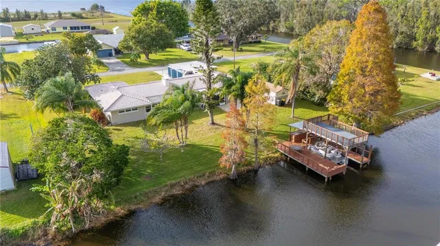 an aerial view of a swimming pool with outdoor seating and yard