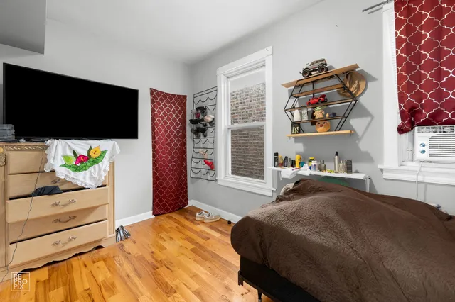 a bedroom with a bed and a flat tv screen on dresser