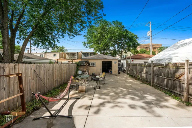 a view of a chair and tables in backyard