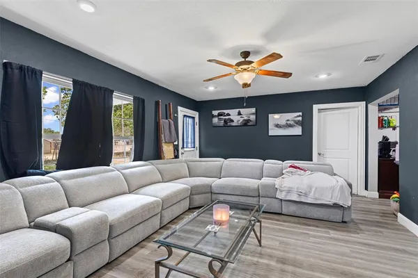 a living room with furniture ceiling fan and a rug