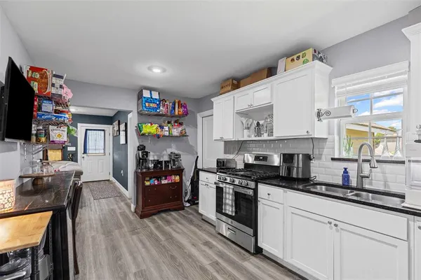 a kitchen with stainless steel appliances granite countertop a stove and cabinets