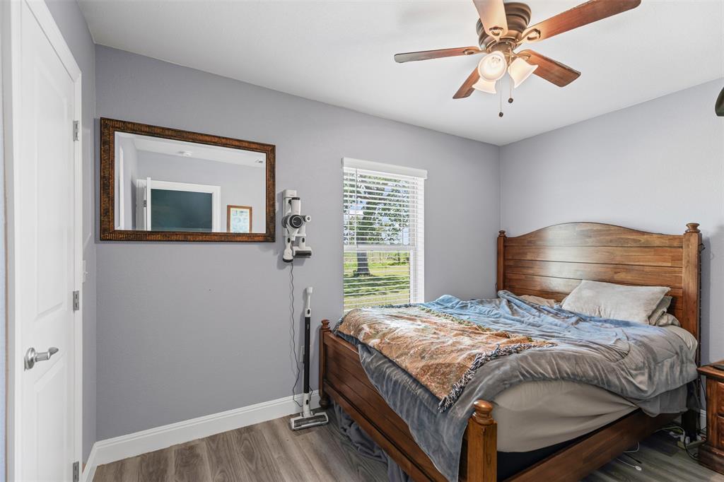 105 South Lavaca Street Whitney, TX 76692 - Photo 18 of 40 a bedroom with a bed and a chandelier