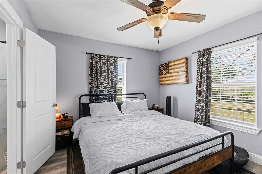 105 South Lavaca Street Whitney, TX 76692 - Photo 21 of 40 a bedroom with a large bed and a chandelier