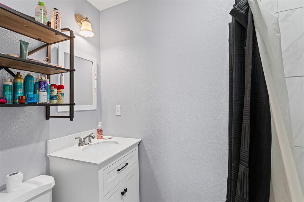 105 South Lavaca Street Whitney, TX 76692 - Photo 22 of 40 a bathroom with a sink vanity and toilet