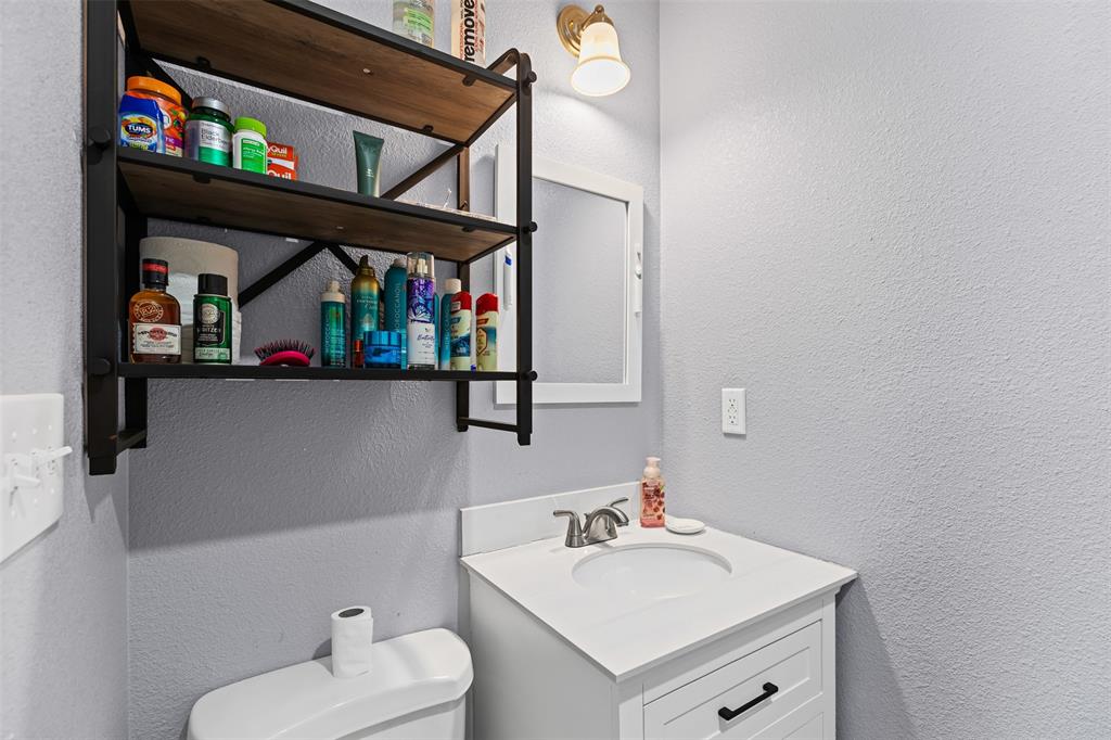 105 South Lavaca Street Whitney, TX 76692 - Photo 24 of 40 a bathroom with a sink a toilet and a mirror