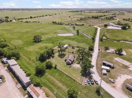 an aerial view of ocean and residential houses with outdoor space
