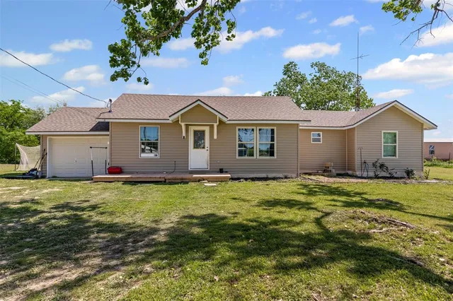 a view of a house with a backyard
