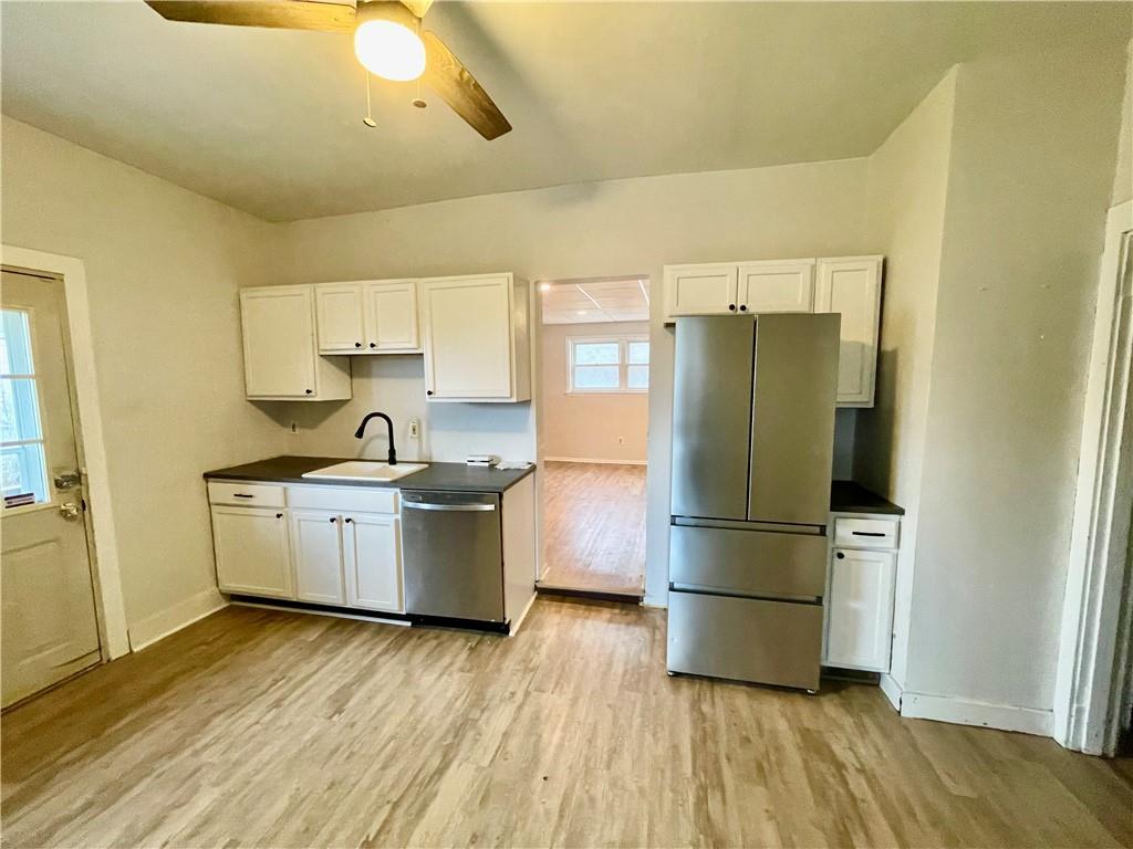 141 Overbeck Street Pittsburgh, PA 15212 - Photo 12 of 29 a kitchen with a refrigerator a sink dishwasher a stove and white cabinets with wooden floor