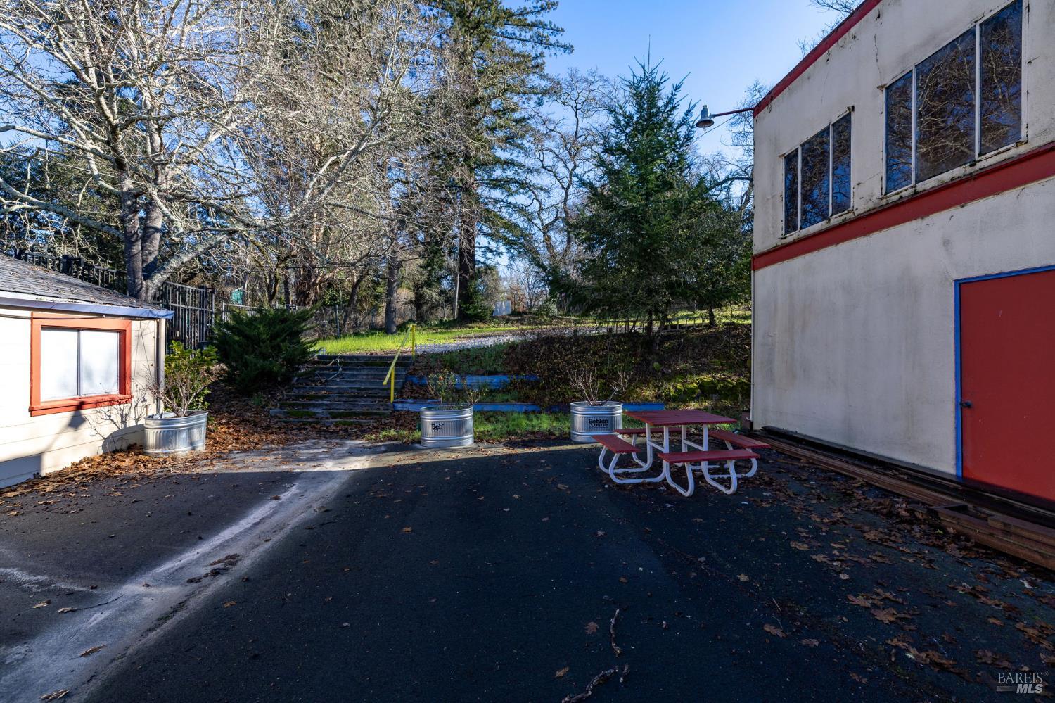 8877 Donald Street Sebastopol, CA 95472 - Photo 15 of 55 a view of a patio with table and chairs under an umbrella with large trees
