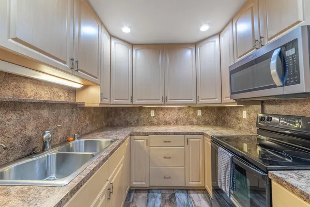 a kitchen with granite countertop stainless steel appliances sink and cabinets