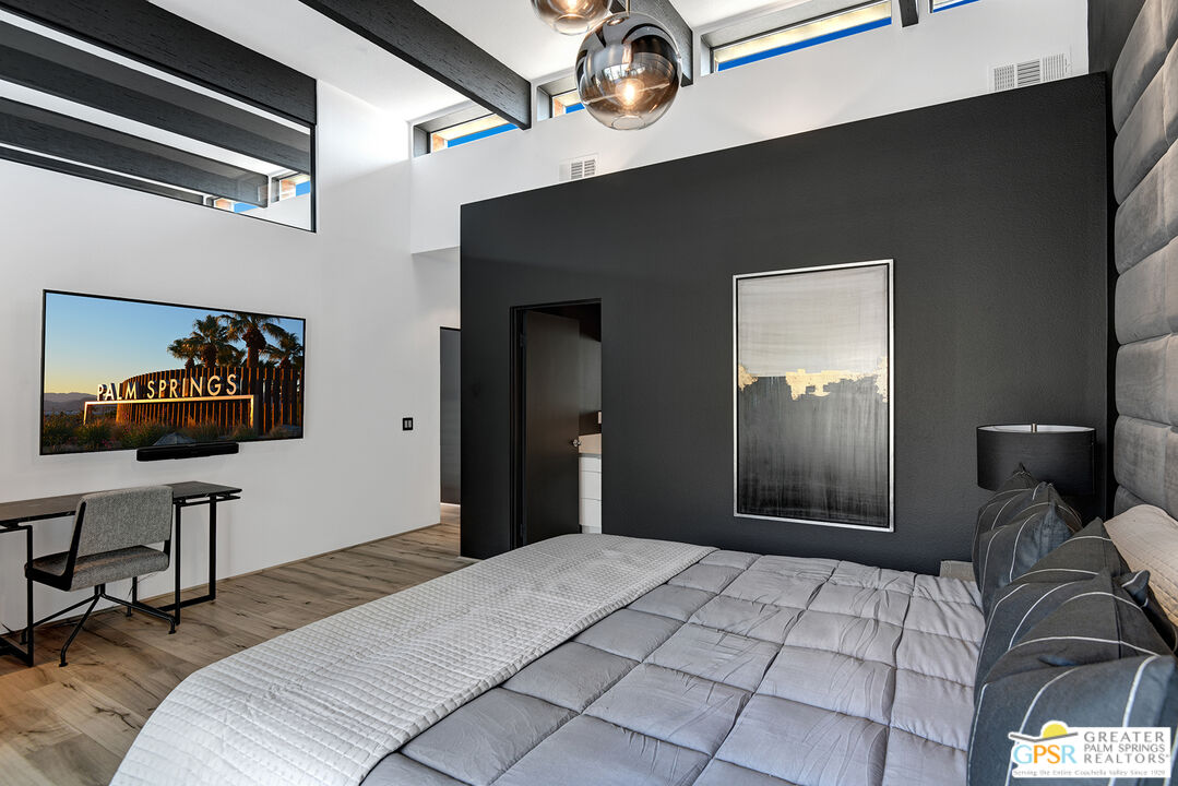 1508 East Baristo Road Palm Springs, CA 92262 - Photo 41 of 62 a bedroom with a bed and a chandelier