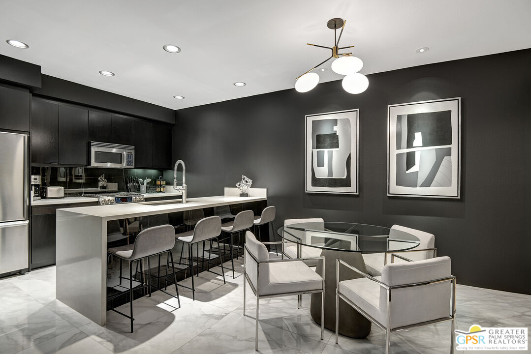 1508 East Baristo Road Palm Springs, CA 92262 - Photo 57 of 62 a kitchen with a dining table chairs sink and cabinets