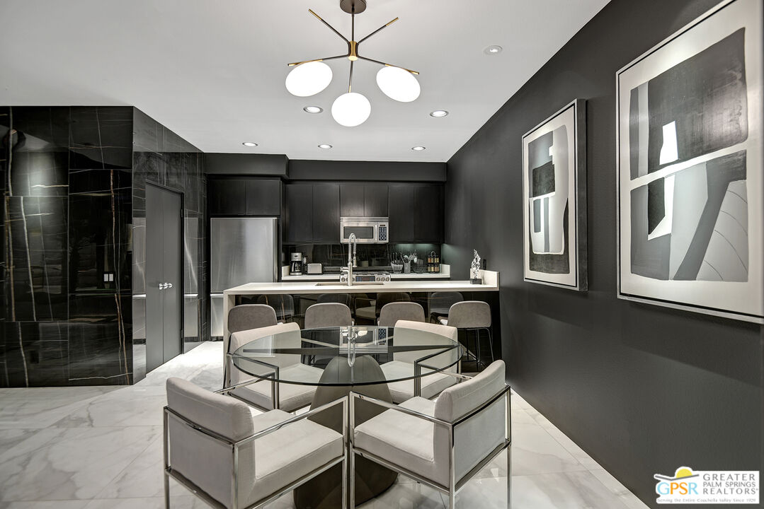 1508 East Baristo Road Palm Springs, CA 92262 - Photo 58 of 62 a kitchen with stainless steel appliances kitchen island granite countertop a refrigerator a stove and a sink with wooden floor