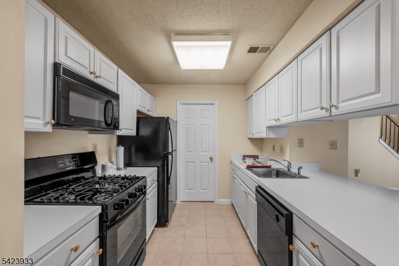 159 West Market Street Newark, NJ 07103 - Photo 6 of 18 a kitchen with stainless steel appliances a sink a stove a microwave a refrigerator a sink and cabinets