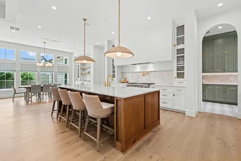 a kitchen with stainless steel appliances granite countertop a kitchen island a stove and a wooden floors
