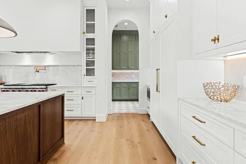 a hallway with cabinets and wooden floor