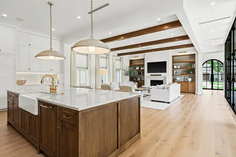 a large kitchen with kitchen island a large island in the center a sink stainless steel appliances and cabinets