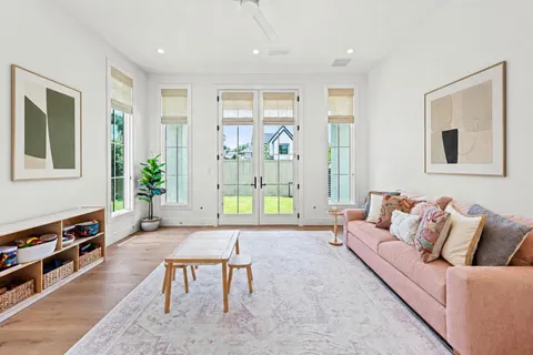 a living room with furniture a flat screen tv and a window