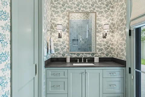 a bathroom with a granite countertop sink a vanity and a shower