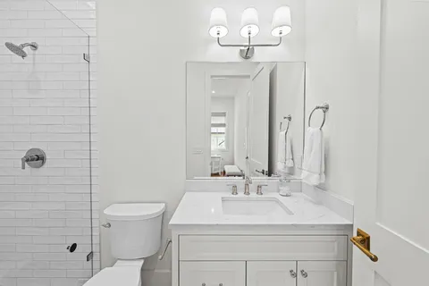 a bathroom with a sink a toilet and shower