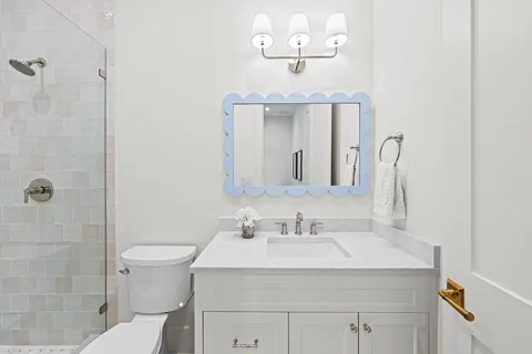 a bathroom with a sink a toilet and a mirror