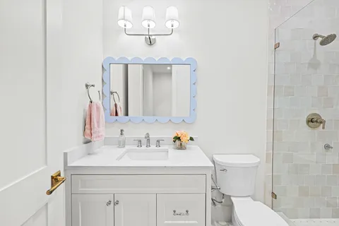 a bathroom with a sink a toilet and mirror