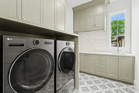 a utility room with sink dryer and washer