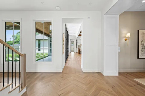 a view of a hallway with wooden floor and windows