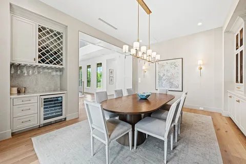 a dining room with furniture a chandelier and wooden floor