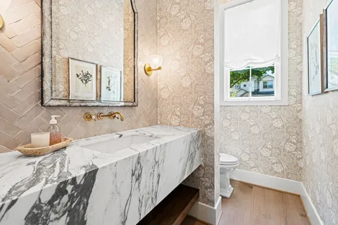 a bathroom with a sink a toilet and a window
