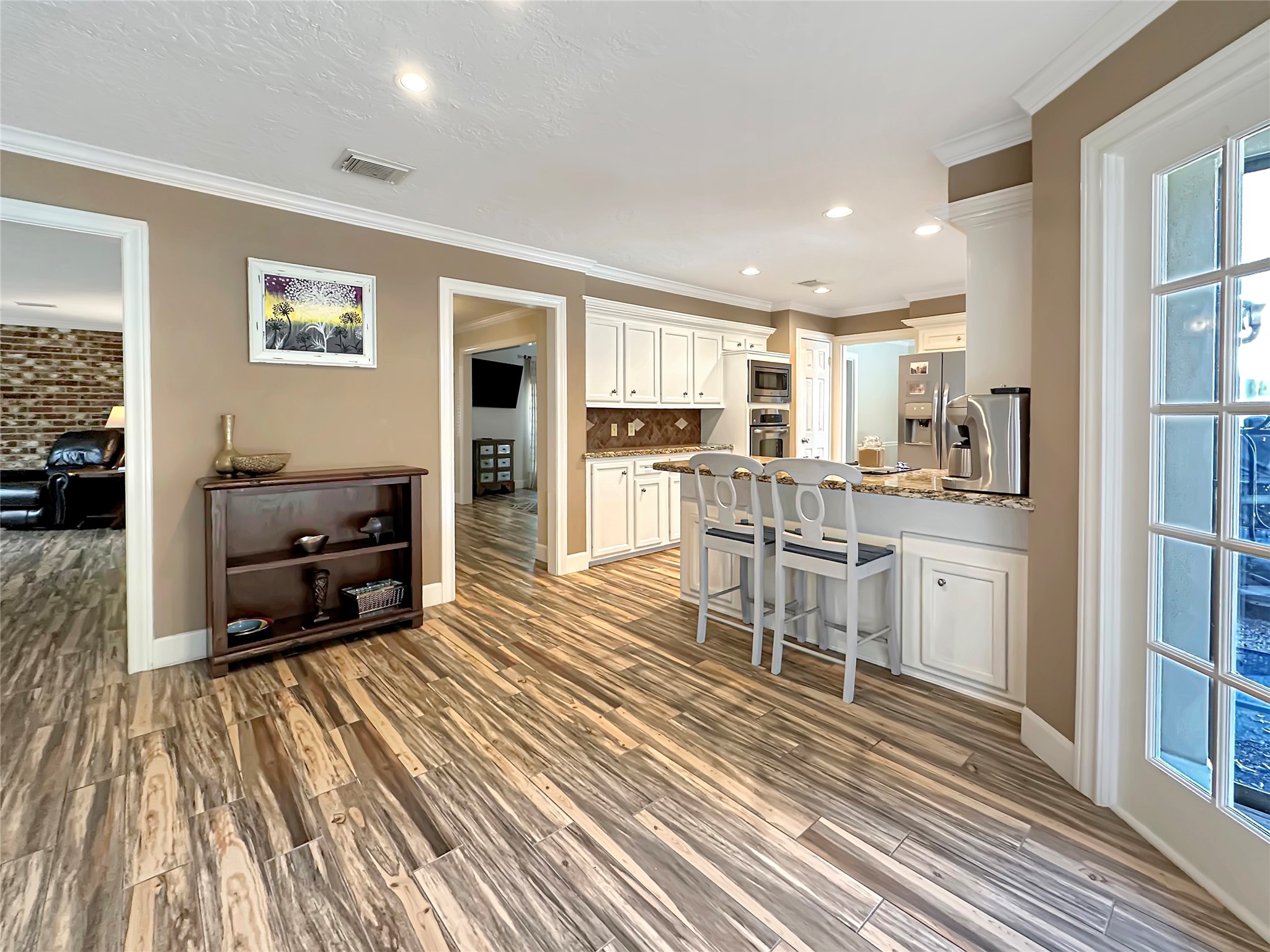 17418 Spicewood Springs Lane Spring, TX 77379 - Photo 8 of 50 a kitchen with stainless steel appliances a stove a sink and white cabinets with wooden floor