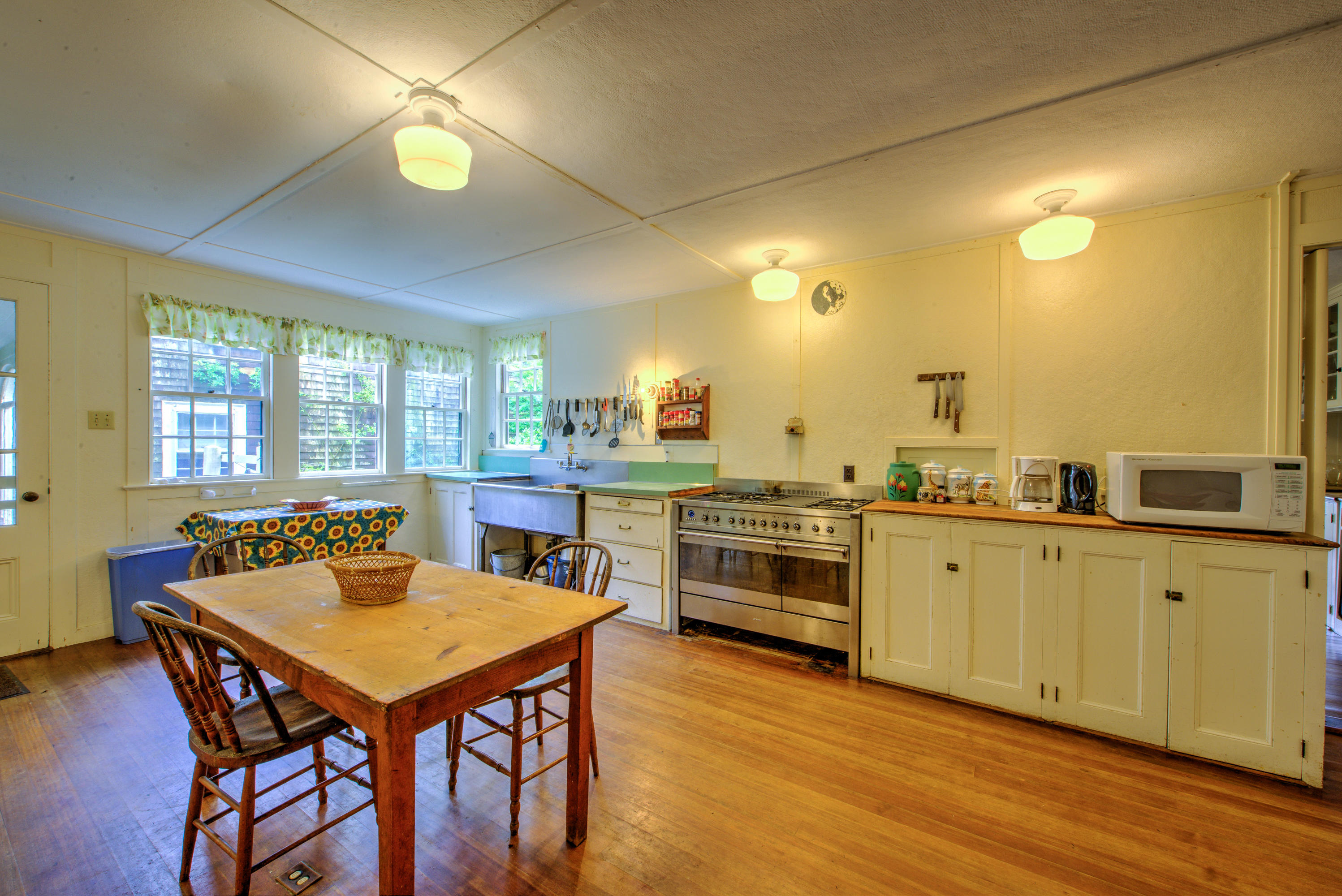 188 Gansett Road Woods Hole, MA 02543 - Photo 15 of 26 a kitchen with stainless steel appliances granite countertop a stove a sink a microwave dining table and chairs