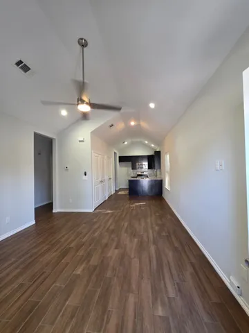a view of empty room with wooden floor and stove