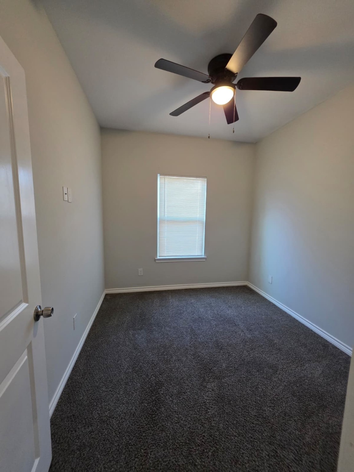 16338 Eastchase Street Montgomery, TX 77316 - Photo 8 of 12 an empty room with a chandelier fan and windows