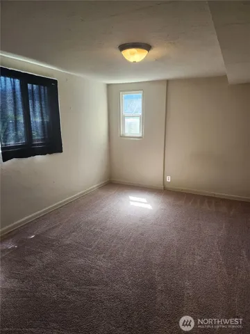 an empty room with windows and closet