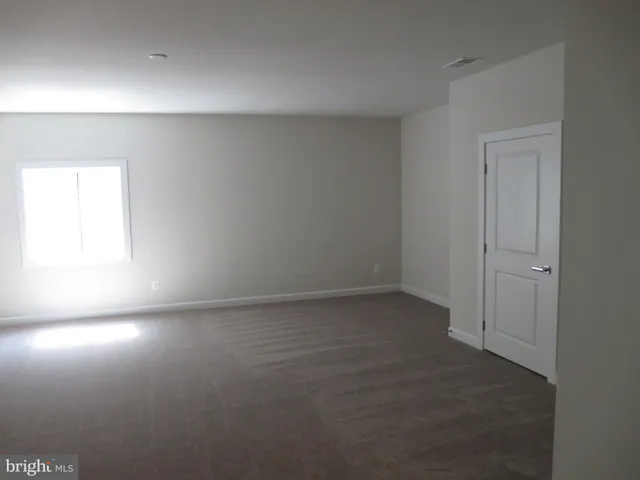 a view of empty room with wooden floor and windows