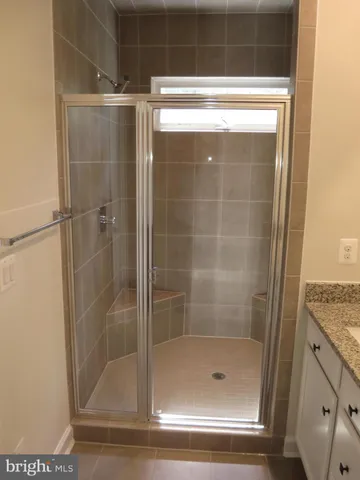 a bathroom with a granite countertop toilet and a bathtub