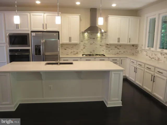 a kitchen with stainless steel appliances a sink and a refrigerator