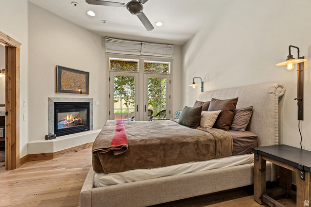105 River Bend Circle, Unit 105 Springdale, UT 84767 - Photo 16 of 56 Room featuring wood-finish flooring, a corner-set fireplace with a stone surround, and double French doors with transom windows