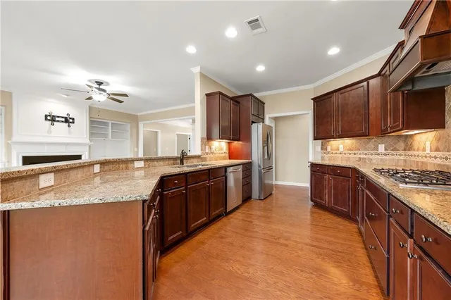 a large kitchen with stainless steel appliances granite countertop a stove a sink dishwasher and a refrigerator