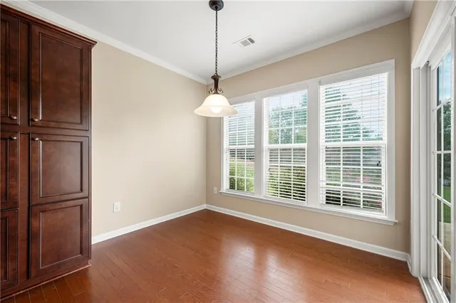 a view of empty room with wooden floor and windows