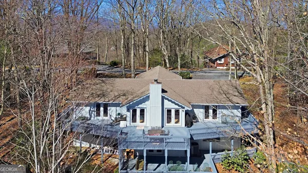 a view of house with a yard and large trees