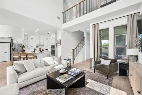 a living room with furniture and a dining table with kitchen view