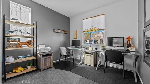 a view of a workspace with furniture and a window