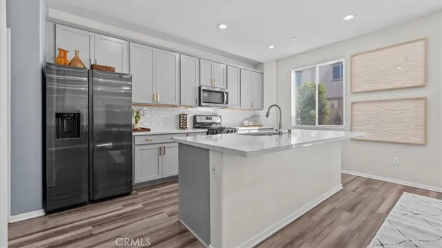 a kitchen with a refrigerator sink and cabinets