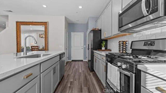 a kitchen with stainless steel appliances a sink stove and cabinets