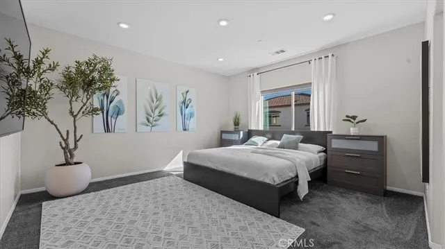 a bedroom with a large bed and a potted plant